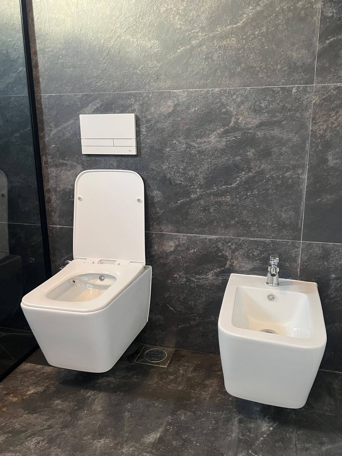 WC dhe bide të bardha në banjo me pllaka gri